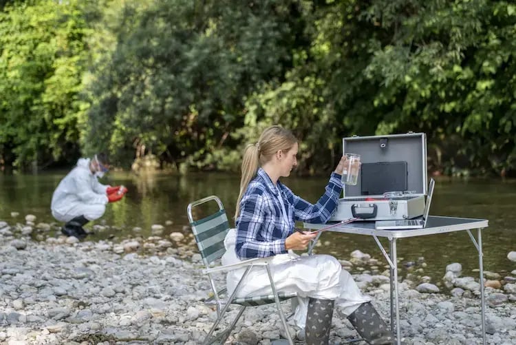 Scientifique testant la qualité de l'eau au bord d'une rivière. Scientifique testant la qualité de l'eau au bord d'une rivière.