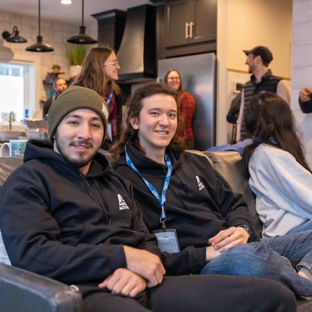 A group of young people from our AquaHacking program in a cozy indoor setting, with two smiling participants wearing AquaHacking hoodies, representing teamwork, innovation, and environmental problem-solving. A group of young people from our AquaHacking program in a cozy indoor setting, with two smiling participants wearing AquaHacking hoodies, representing teamwork, innovation, and environmental problem-solving.